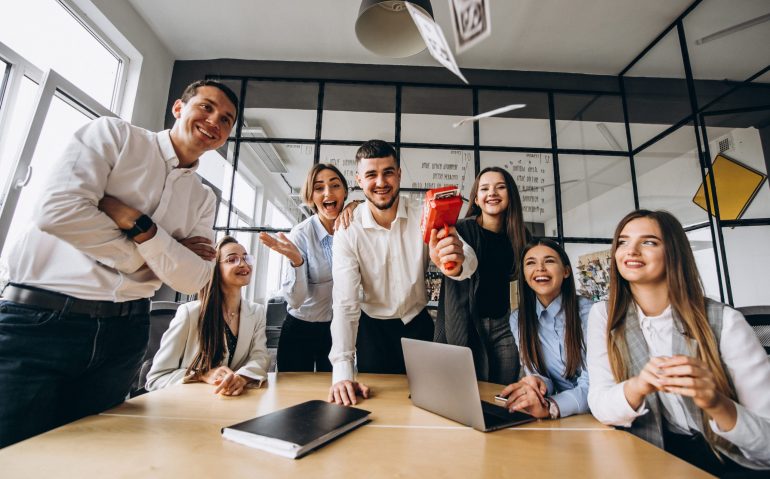 Group of people throwing money in an office